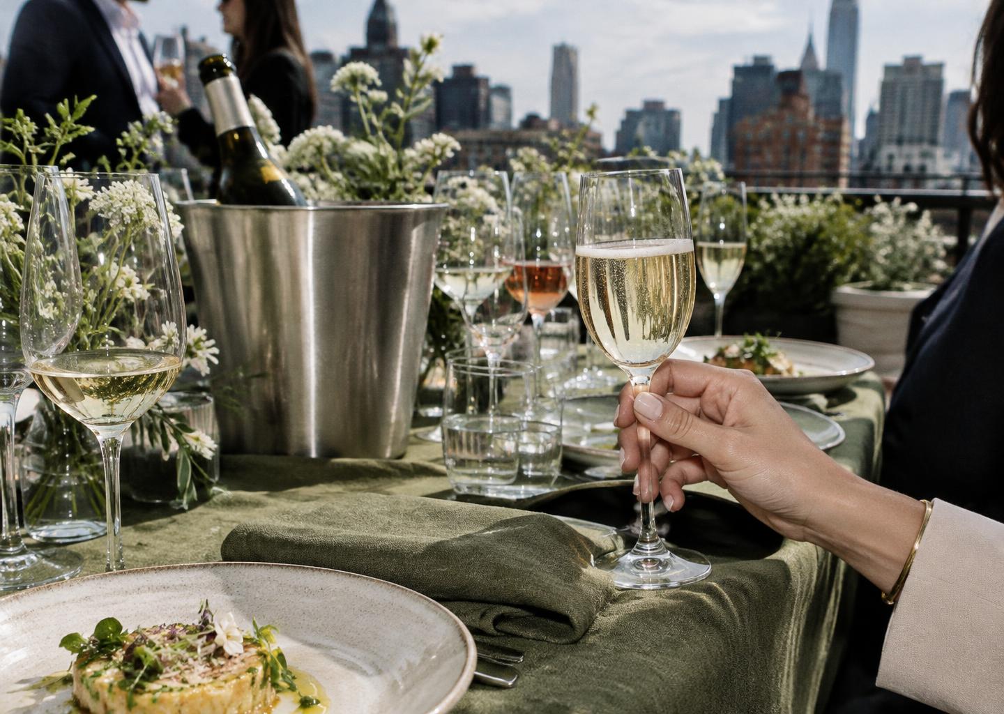 A shared hospitality moment with fine glassware on a New York rooftop